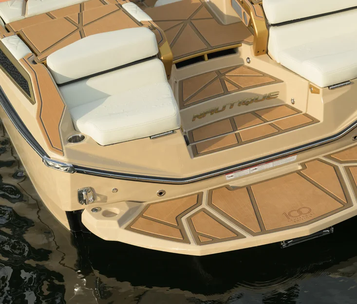 Pont arrière d’un bateau Nautique beige, sellerie blanche et tapis de pont