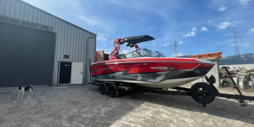 Bateau de wake sur remorque devant le hangar d’hivernage de Motor Boat 74